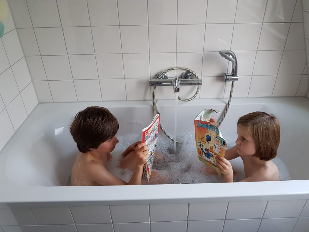 Jonas en Hannah lezen in bad.